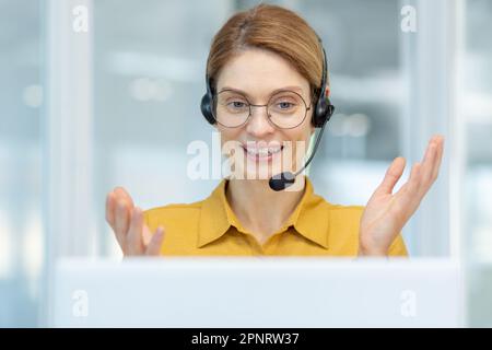 Primo piano di una donna d'affari di successo che lavora a distanza da casa, lavoratore del centro logistico online di trasporto sorridendo e consultando i clienti, donna in camicia ufficio di lavoro seduto dalla finestra. Foto Stock