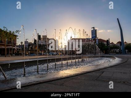 Il sole tramonta dietro la fontana in Piazza Kennedy, la città vecchia di Pafos, Cipro. Foto Stock