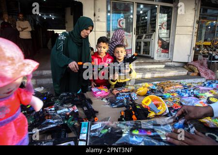 I palestinesi acquistano i fucili giocattolo in un mercato in vista della vacanza Eid al-Fitr nella parte meridionale di Gaza a Rafah, giovedì 20 aprile 2023. I musulmani di tutto il mondo si stanno preparando per la festa di Eid al-Fitr che inizia all'inizio di aprile 21, segnando la fine del santo mese del digiuno del Ramadan. Le preparazioni includono l'acquisto di nuovi vestiti, giocattoli e dolci speciali. Foto di Ismael Mohamad/UPI Credit: UPI/Alamy Live News Foto Stock