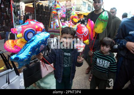 I palestinesi acquistano giocattoli in un mercato in vista della vacanza Eid al-Fitr nel sud di Gaza a Rafah, giovedì 20 aprile 2023. I musulmani di tutto il mondo si stanno preparando per la festa di Eid al-Fitr che inizia all'inizio di aprile 21, segnando la fine del santo mese del digiuno del Ramadan. Le preparazioni includono l'acquisto di nuovi vestiti, giocattoli e dolci speciali. Foto di Ismael Mohamad/UPI Credit: UPI/Alamy Live News Foto Stock