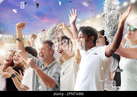 Tifoso di calcio allo stadio in camicia bianca e nera. Tifosi felici sul campo da calcio che guardano il gioco di squadra vincente. Gruppo di tifosi entusiasti. Foto Stock