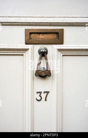 Bussatore e numeri per portoni in ottone Foto Stock