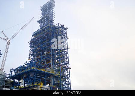 Costruzione con l'aiuto di gru di un grande impianto chimico in una raffineria di petrolio, impianto petrolchimico. Foto Stock