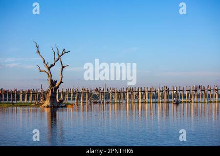 Amarapura, Myanmar - 22 novembre 2016: Persone non identificate camminano sul ponte U Bein al tramonto in Myanmar. Il ponte U Bein è il ponte in teak più lungo del Th Foto Stock