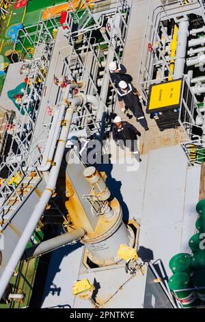 Ponte aperto della nave che rifornisce la nave di servizio della autocisterna in servizio. Tubazioni. Autocisterna, dall'alto. Passerella con equipaggio. Foto Stock