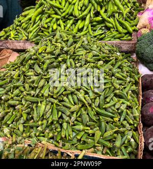 Pila di ripe okra per la vendita a livello locale mercato degli agricoltori Foto Stock