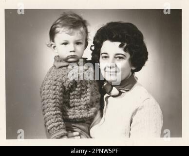 BRNO, REPUBBLICA CECOSLOVACCA, CIRCA 1972: Foto retrò di madre e di suo figlio. Foto ritratto è stata scattata in studio fotografico, foto con tinta scura, circa Foto Stock