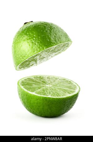Volare in aria fetta di calce isolato su sfondo bianco. Lime con percorso di ritaglio. Succo di lime levitante. Calce tagliata a metà. Foto Stock
