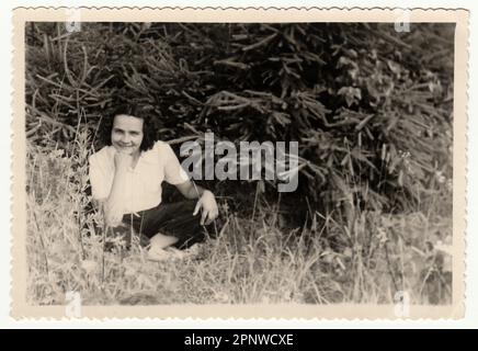 La foto d'epoca mostra una donna seduta all'aperto. Foto Stock
