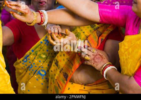 Rituale Gaye holud del matrimonio indù bengalese dove i parenti di sposa e sposo applicano pasta curcuma su di loro come benedizione e celebrazione. Donne in Foto Stock