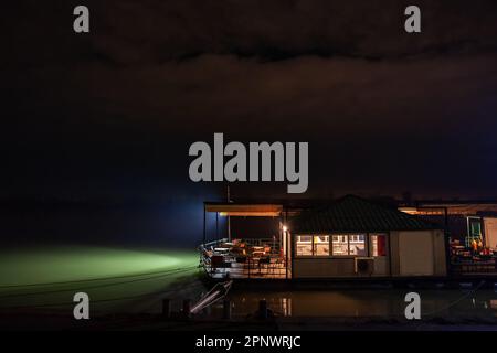 Immagine di una barca utilizzata come ristorante sul Danubio al tramonto d'inverno a Belgrado, capitale della Serbia, chiamata splav, o zattera in serbia. Foto Stock