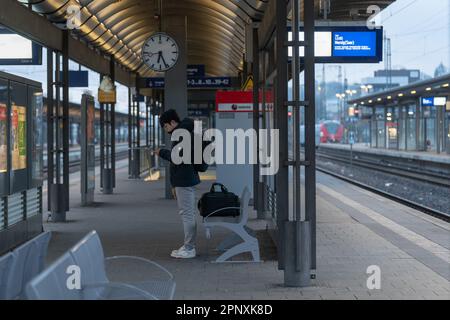 Kaiserslautern, Germania. 21st Apr, 2023. Viaggiatore maschio in attesa di un treno durante scioperi nazionali, ignaro della situazione. Lo sciopero è stato avviato dall'Unione ferroviaria e dei trasporti EVG dopo il fallimento dei negoziati salariali con la Deutsche Bahn (DB). I membri del sindacato sono stati invitati a interrompere tutti i servizi ferroviari venerdì dalle 3 alle 11 Credit: Gustav Zygmund/Alamy News Foto Stock