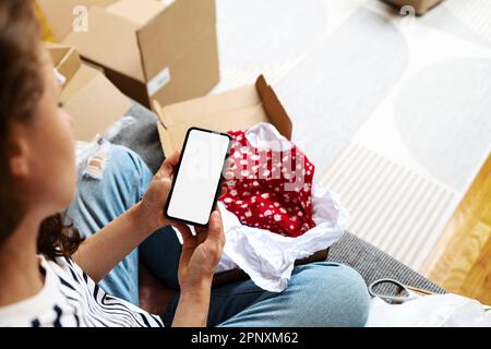 Immagine mockup di una persona che tiene in mano il telefono cellulare con schermo vuoto, utilizzando l'app mobile del negozio online, servizio di consegna. Foto Stock