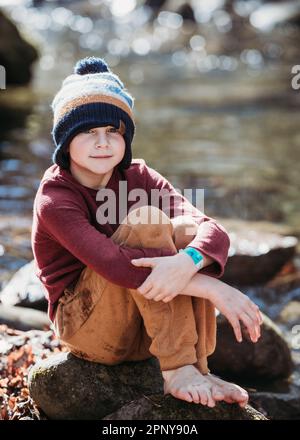 Ritratto di giovane ragazzo su rocce in natura Foto Stock