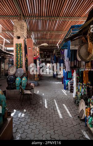 Strada nella medina di Marrakech con una moltitudine di piccoli negozi di souvenir. Foto Stock
