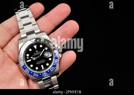 Bangkok Thailandia - Febbraio 20,2022 : tenuta di mano Rolex GMT-Master II 'Batman'40mm con lunetta blu-nera acciaio Ceramica orologio da uomo da polso su sfondo nero Foto Stock