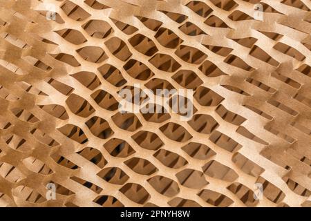 Grande foto ravvicinata di carta riempitrice a nido d'ape frantumata utilizzata nei processi di movimentazione dei materiali per la spedizione di merci o prodotti delicati. Foto Stock