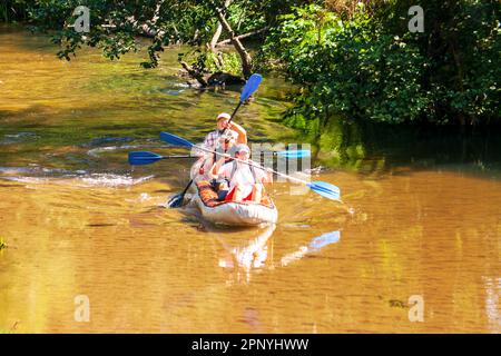 Minsk Regione, Bielorussia - 26 luglio 2014: I turisti rafting in una barca gonfiabile su un fiume foresta Foto Stock