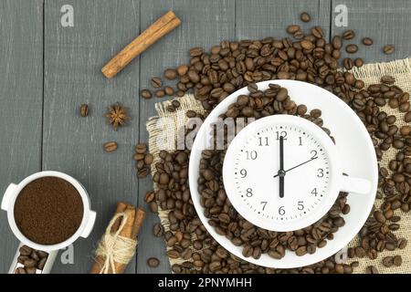 Sveglia in una tazza di caffè. Foto creativa. Confluence Cup di espresso fresco con cartello con l'orologio, vista dall'alto. Spazio per il testo Foto Stock