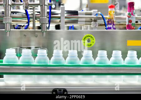 Bianco di bottiglie di plastica trasferire sul trasportatore automatizzato di sistemi di automazione industriale per il pacchetto Foto Stock