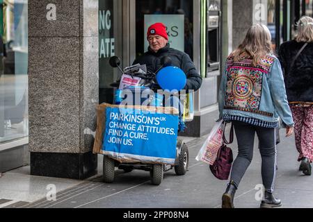 'Change Attitudes, Find Cure'  mese di consapevolezza del Parkinson Aprile 2023; uomo disabile in sedia a rotelle a motore raccolta per la ricerca a Southport, Merseyside, Regno Unito Foto Stock