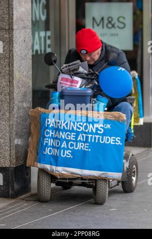 'Change Attitudes, Find Cure'  mese di consapevolezza del Parkinson Aprile 2023; uomo disabile in sedia a rotelle a motore raccolta per la ricerca a Southport, Merseyside, Regno Unito Foto Stock