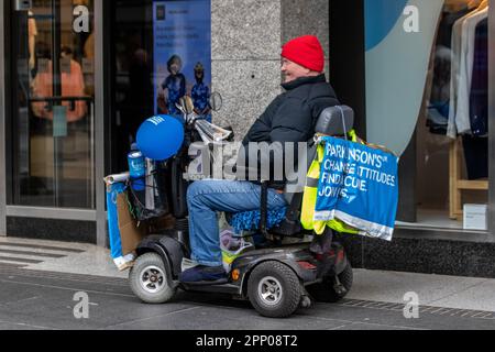 'Change Attitudes, Find Cure'  mese di consapevolezza del Parkinson Aprile 2023; uomo disabile in sedia a rotelle a motore raccolta per la ricerca a Southport, Merseyside, Regno Unito Foto Stock