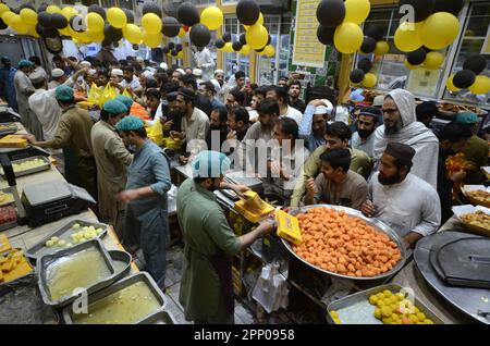 Peshawar, Pakistan. 20th Apr, 2023. La gente acquista dolci tradizionali in preparazione alle prossime celebrazioni di Eid al-Fitr in un negozio di Peshawar. EID al-Fitr segna la fine del mese santo islamico del Ramadan. (Foto di Hussain Ali/Pacific Press) Credit: Pacific Press Media Production Corp./Alamy Live News Foto Stock