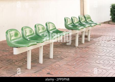 Sedia di plastica verde alla fermata dell'autobus per i passeggeri in attesa Foto Stock