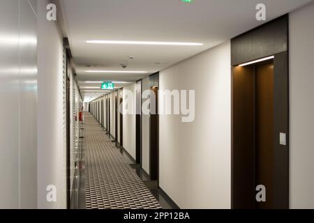 Vista sul lungo corridoio dell'hotel, molte porte su entrambi i lati. Foto Stock