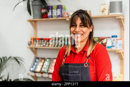 Donna latina felice che lavora all'interno del supermercato - concetto di cibo al dettaglio Foto Stock