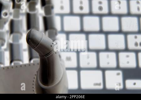 Mano del robot con una tastiera concettuale come sfondo . Foto Stock