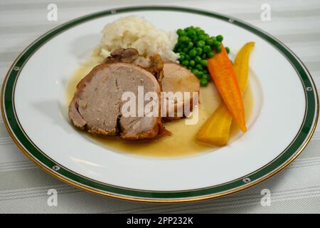 Arrosto di vitello con rene o Kalbsbraten in stile austriaco con riso, piselli e sugo di carne Foto Stock