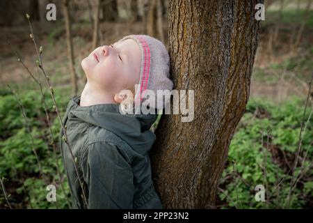 energia dell'albero: ragazza carica di energia positiva dell'albero, sensibilità l'interazione con la natura ed il sostegno dall'ambiente Foto Stock