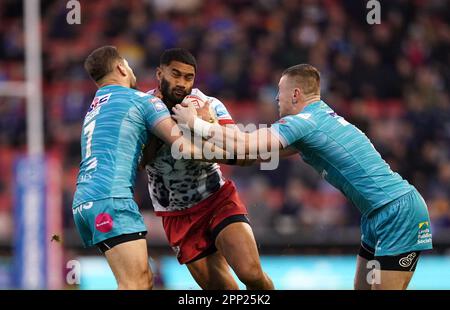 Ricky Leutele di Leigh Leopardi è affrontato da Leeds Rhinos' Aidan Sezer (a sinistra) e Harry Newman durante la partita della Betfred Super League al Leigh Sports Village, Leigh. Data immagine: Venerdì 21 aprile 2023. Foto Stock