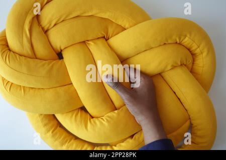 tenendo un cuscino di colore giallo , Foto Stock