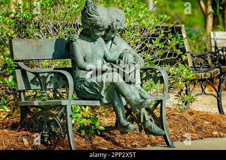 Una scultura in bronzo di due bambini che leggono è raffigurata alla biblioteca pubblica di Bay Minette, il 16 aprile 2023, a Bay Minette, Alabama. Foto Stock