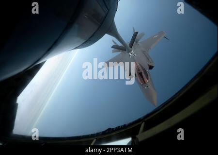 NEGLI STATI UNITI Air Force F-35A Lightning II assegnato al 355th Fighter Squadron riceve carburante da uno Squadron Air Refuelling 909th KC-135 Stratotanker Over the Yellow Sea, 18 aprile 2023. Il F-35s integrato con l'aereo B-52H Stratofortress, bombardieri capaci di colpire di precisione a lungo raggio, in grado di supportare gli obiettivi di sicurezza nazionale in qualsiasi regione. Queste capacità consentono agli Stati Uniti e alle forze alleate di sostenere un indo-Pacifico libero e aperto. (STATI UNITI Foto dell'aeronautica militare di Jessi Roth) Foto Stock