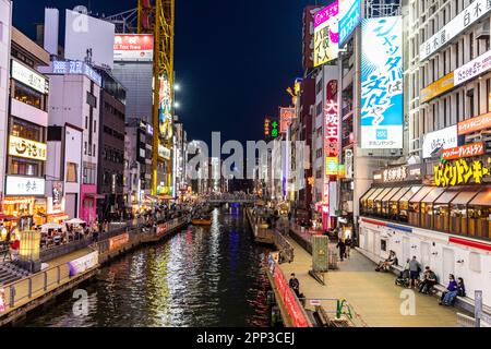 Osaka Giappone 2023 aprile, canale del fiume Dotonbori di notte con luci al neon e folla che si riuniscono per cena e intrattenimento, Street scene, Giappone Foto Stock