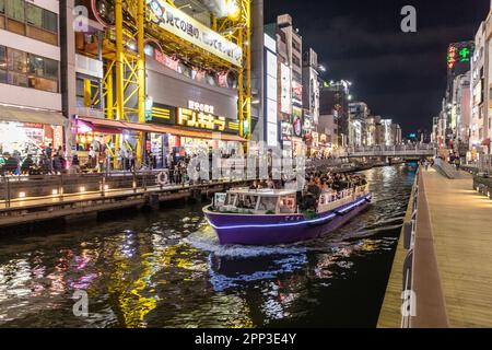 Vita notturna di Osaka 2023 aprile, folle nel quartiere di Dotonbori come una barca sul canale piena di persone si muove attraverso il quartiere, Osaka, Giappone, Asia Foto Stock