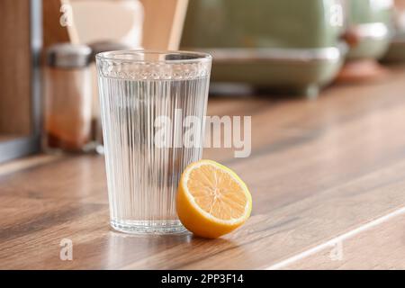 Bicchiere d'acqua e limone sul piano cucina Foto Stock