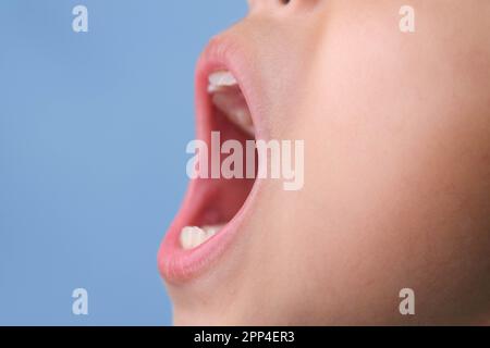 Primo piano vista laterale dell'interno della cavità orale di un bambino sano con belle file di denti. La giovane ragazza apre la bocca rivelando i denti superiori e inferiori, Foto Stock