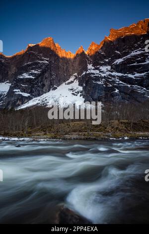 alpenglow di mattina presto sulle cime Trolltindene e Trollveggen, o il Muro di Troll, nella valle di Romsdalen, Rauma kommune, Møre og Romsdal, Norvegia. Foto Stock