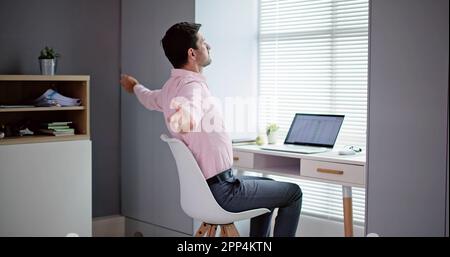 Felice giovane impreditore Stretching Braccia in Office Foto Stock