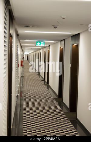 Vista sul lungo corridoio dell'hotel, molte porte su entrambi i lati. Foto Stock