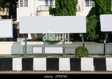 Bianco mockup bianco di una tela del tabellone di affissione di fermata di autobus di fronte allo sfondo vuoto della strada Foto Stock