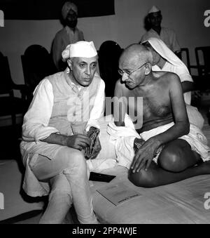 Mahatma Gandhi con Jawaharlal Nehru, ritratti di tre quarti di lunghezza, seduti, a una riunione di All India Congress, Bombay, India. 6 luglio 1946. PH Foto Stock