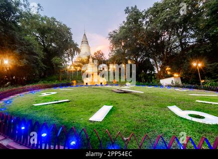 Nei giardini di Wat Penh, un regalo dalla Cina, coperto di erba verde, un grande orologio di lavoro, sotto la pagoda in cima alla collina di Wat Phnom, un importante punto di riferimento della città, n Foto Stock