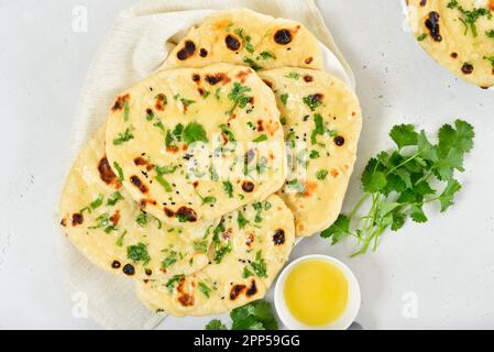 Pane di naan indiano fatto in casa su sfondo di pietra chiara. Vista dall'alto, disposizione piatta Foto Stock