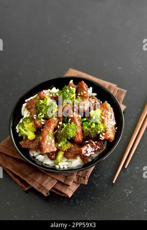 Il manzo e i broccoli si friggano con il riso nel recipiente Foto Stock